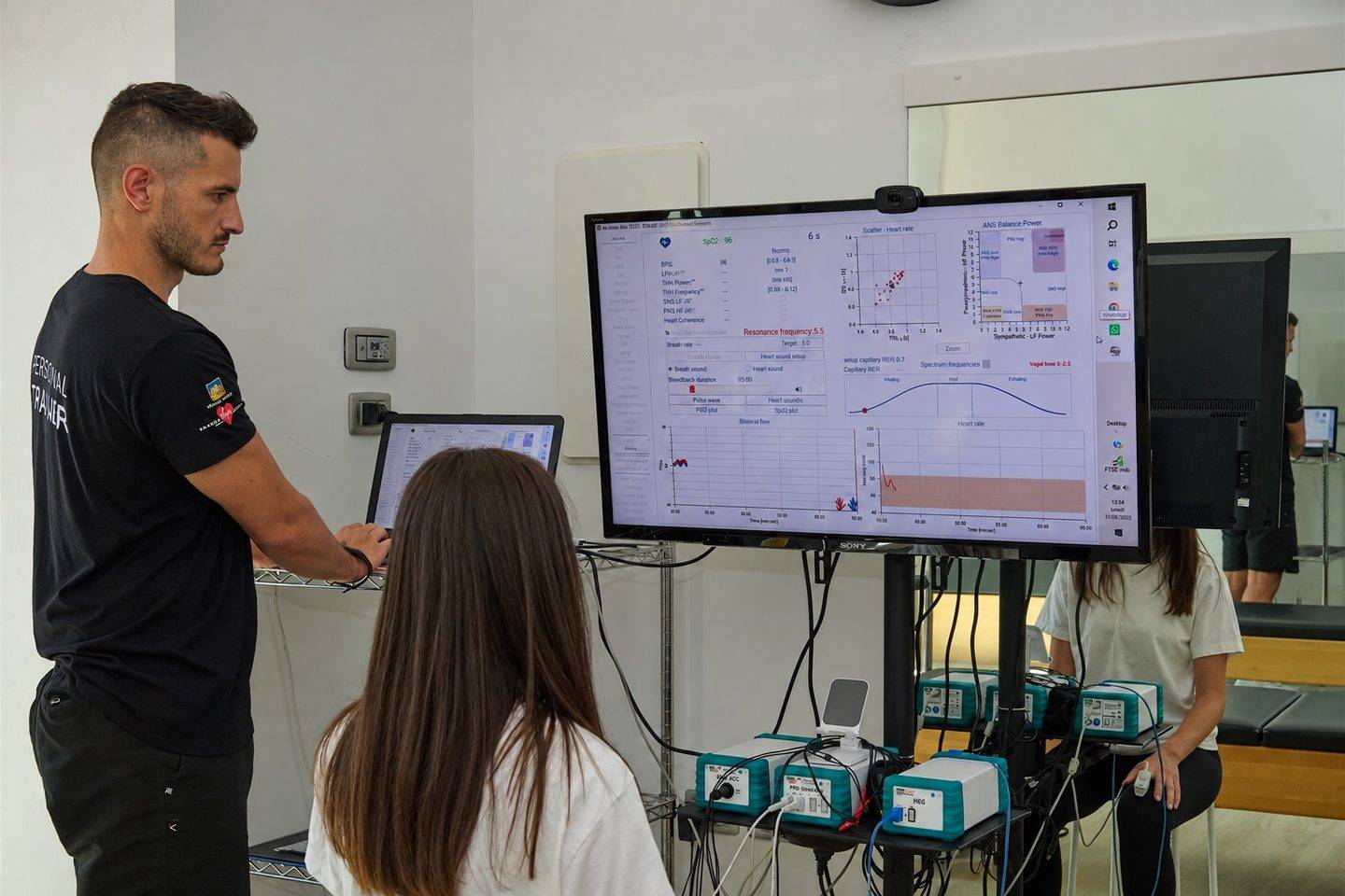 Preparatore atletico e cliente davanti ai grafici di analisi del Bio Sync Method