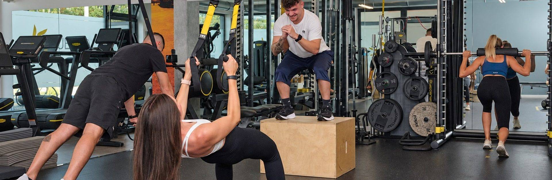 Allenamento funzionale con TRX e step nella sala fitness