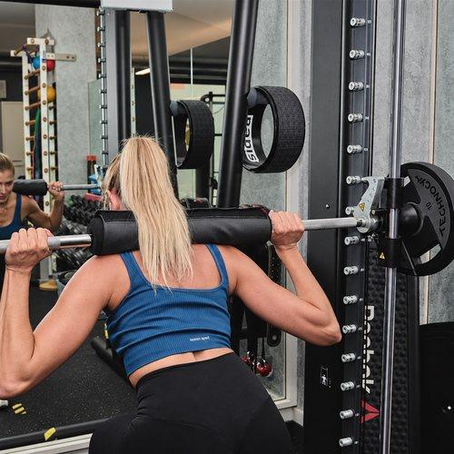 Allieva al multipower durante un allenamento di forza